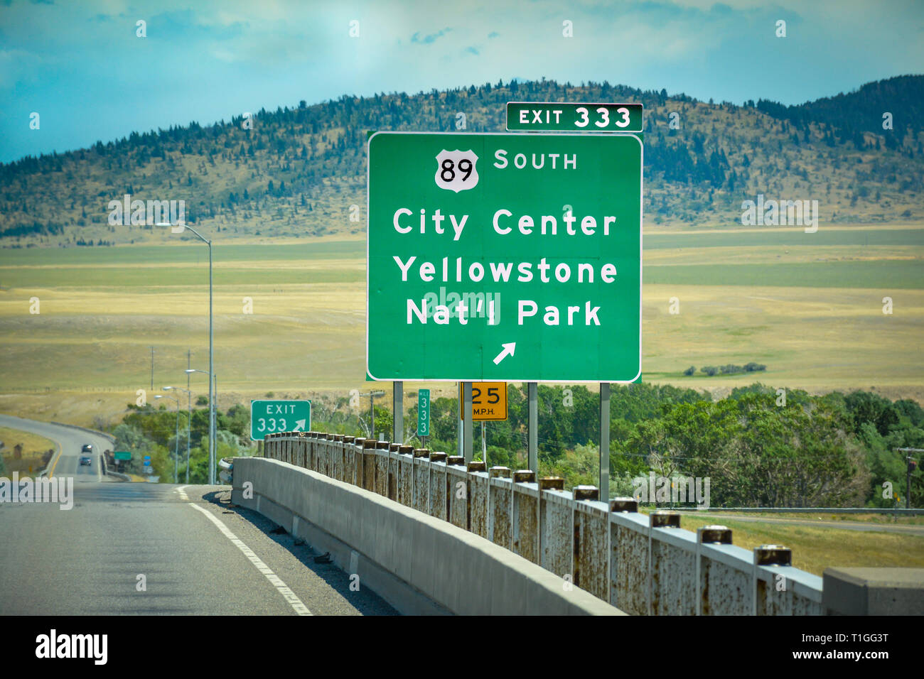 Un verde Montana interstate uscita segno per il sud 89 verso il centro della città e il Parco Nazionale di Yellowstone, con sfondo montano sulla I-90 freeway Foto Stock