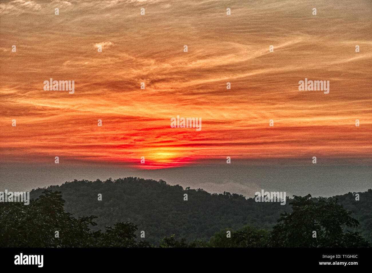 Questa unica immagine mostra il bellissimo tramonto rosso con grande nube formazione dietro le montagne in Hua Hin in Thailandia Foto Stock