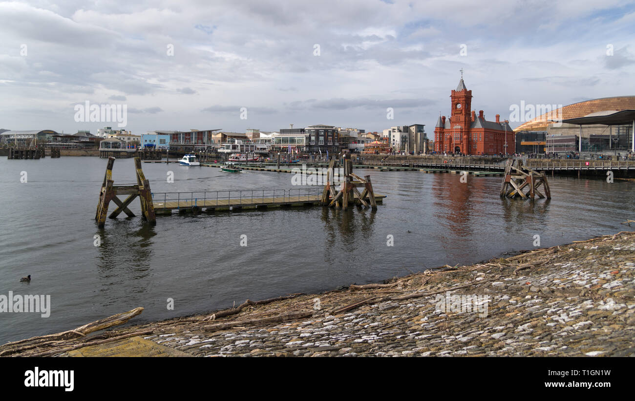 Resti della vecchia banchina di fronte al Mermaid Quay con l'edificio Pierhead e il National Assembly Building, Cardiff, Regno Unito Foto Stock