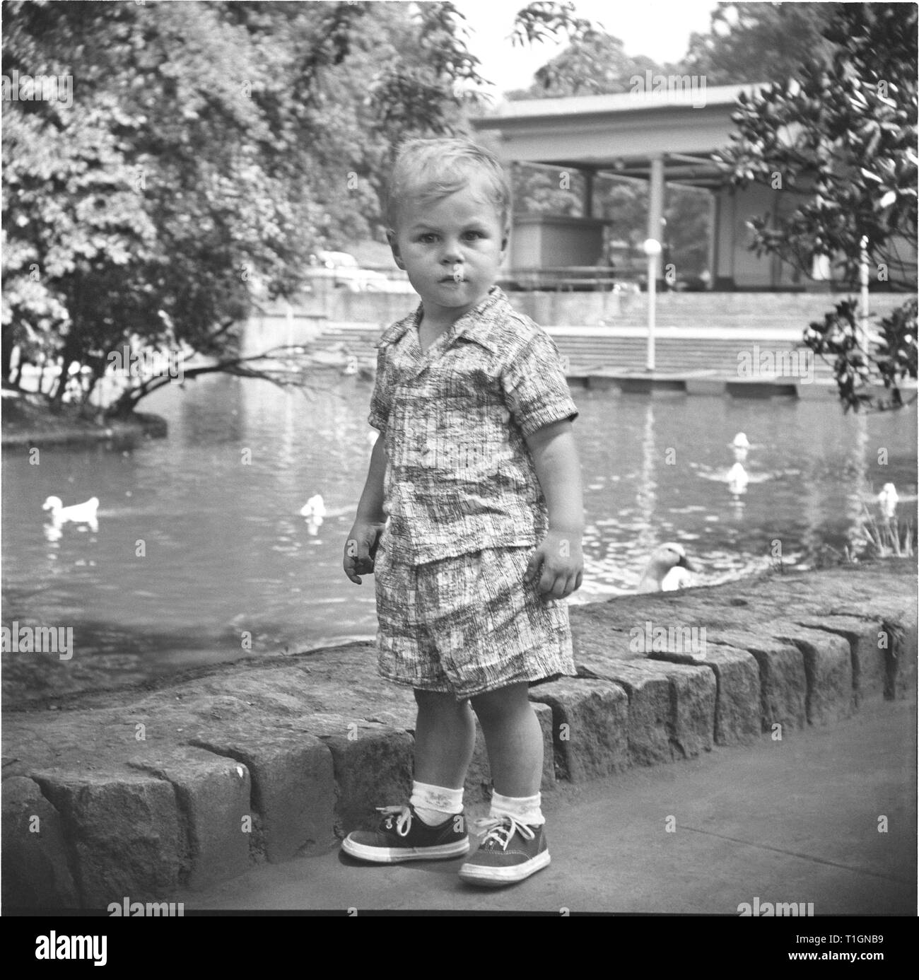 Anni sessanta ragazzo giocando in un parco Foto Stock