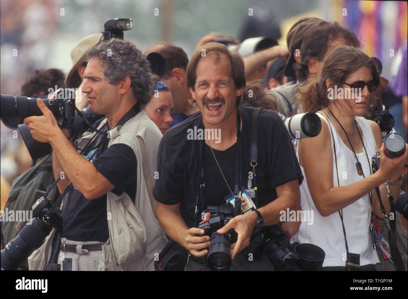 Premere fotografi si sono mostrare lavorando su una piattaforma sopra la folla e sotto il palcoscenico Woodstock 94. Foto Stock