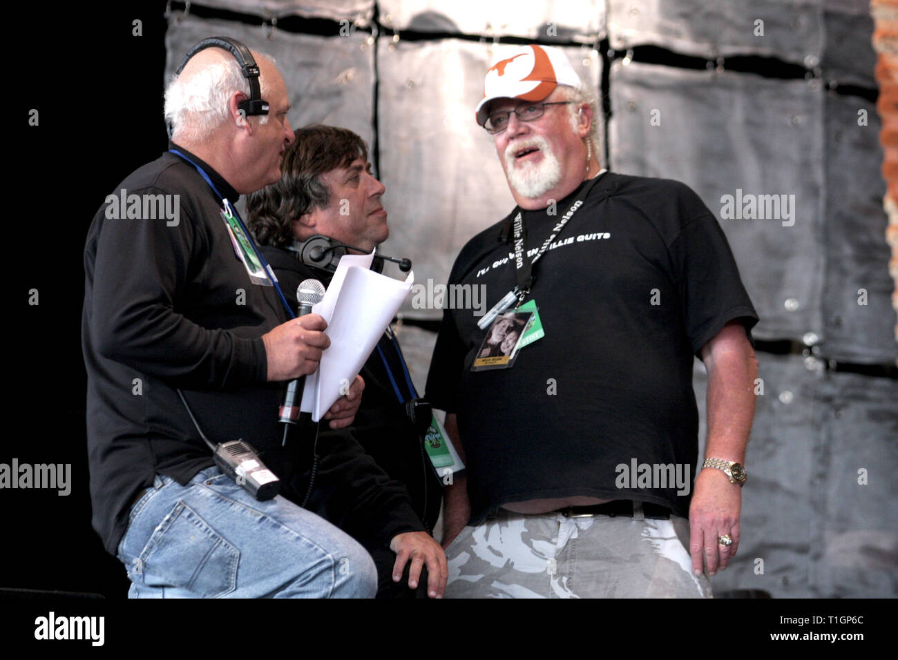 I responsabili di produzione sono mostrati aventi una conversazione prima di iniziare una fattoria concerto di aiuto le prestazioni. Foto Stock