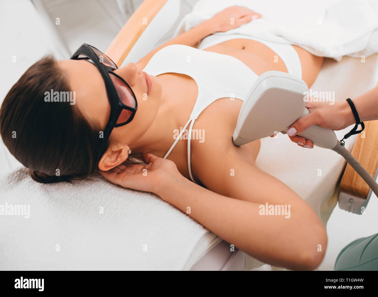Donna con la rimozione dei peli di epilazione laser su zone ascelle. riduzione dei peli Foto Stock