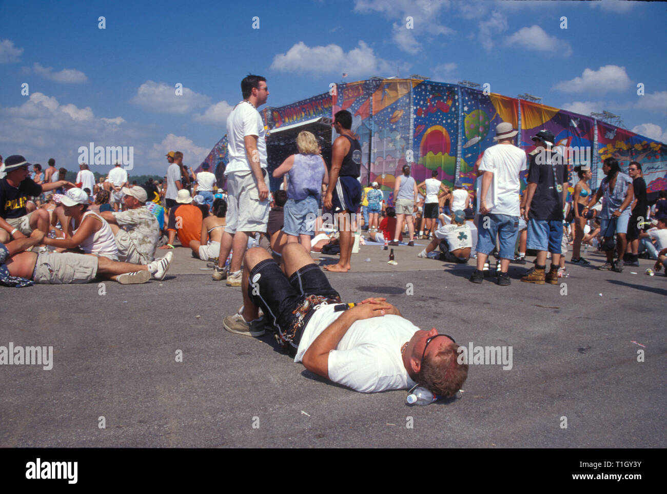 Un concerto ventola è illustrato prendendo una pausa tra le prestazioni durante la Woodstock 99 in Roma, New York. Foto Stock