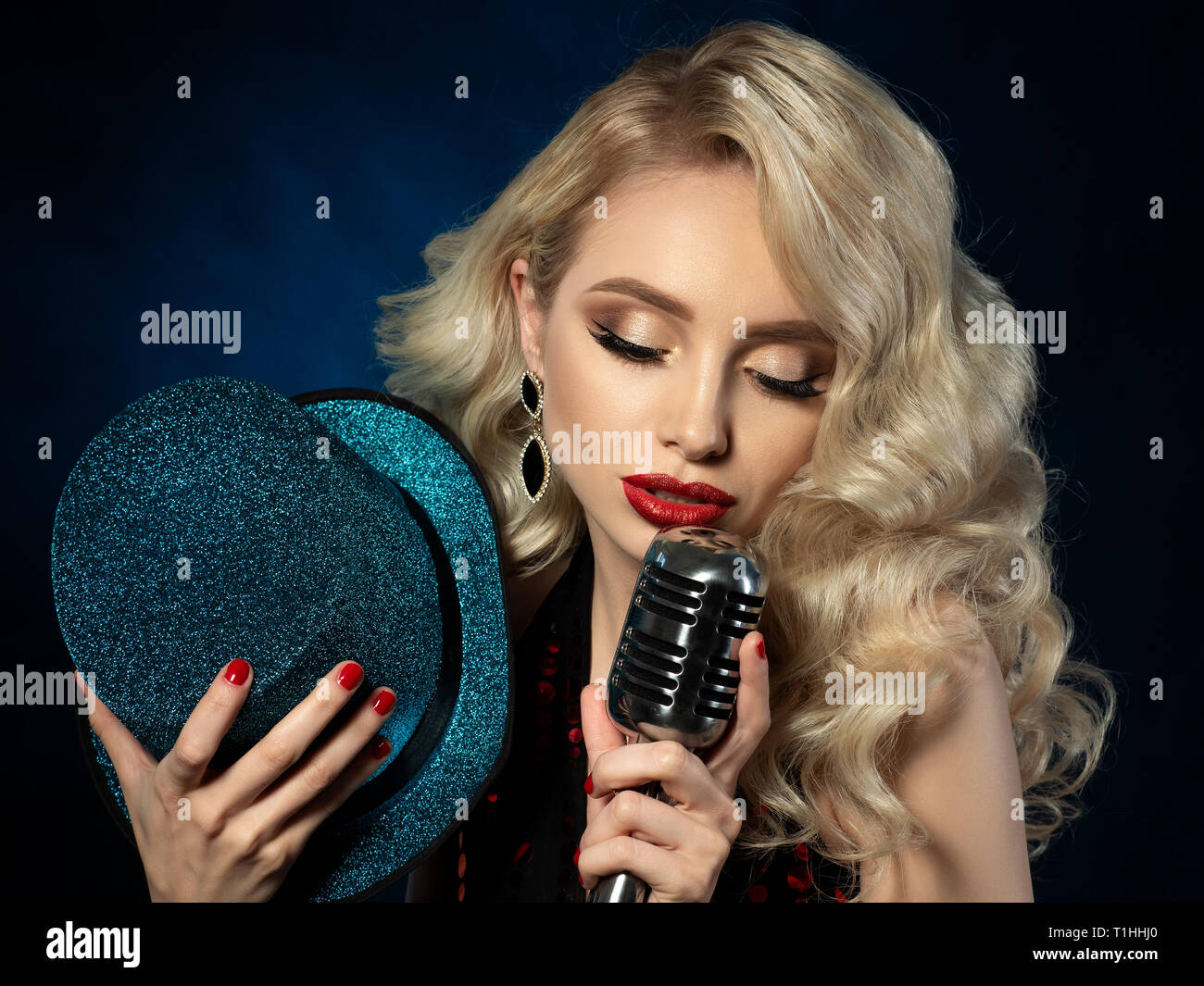 Ritratto di bella bionda cantante femminile tenendo il microfono Foto Stock