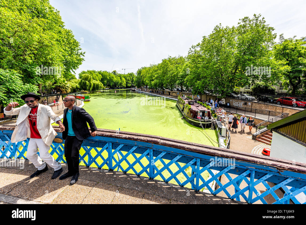 London, Regno Unito - 24 Giugno 2018: Quartiere quartiere di Little Venice Italy canal stile tradizionale barche durante soleggiata giornata estiva e la gente sul ponte Foto Stock