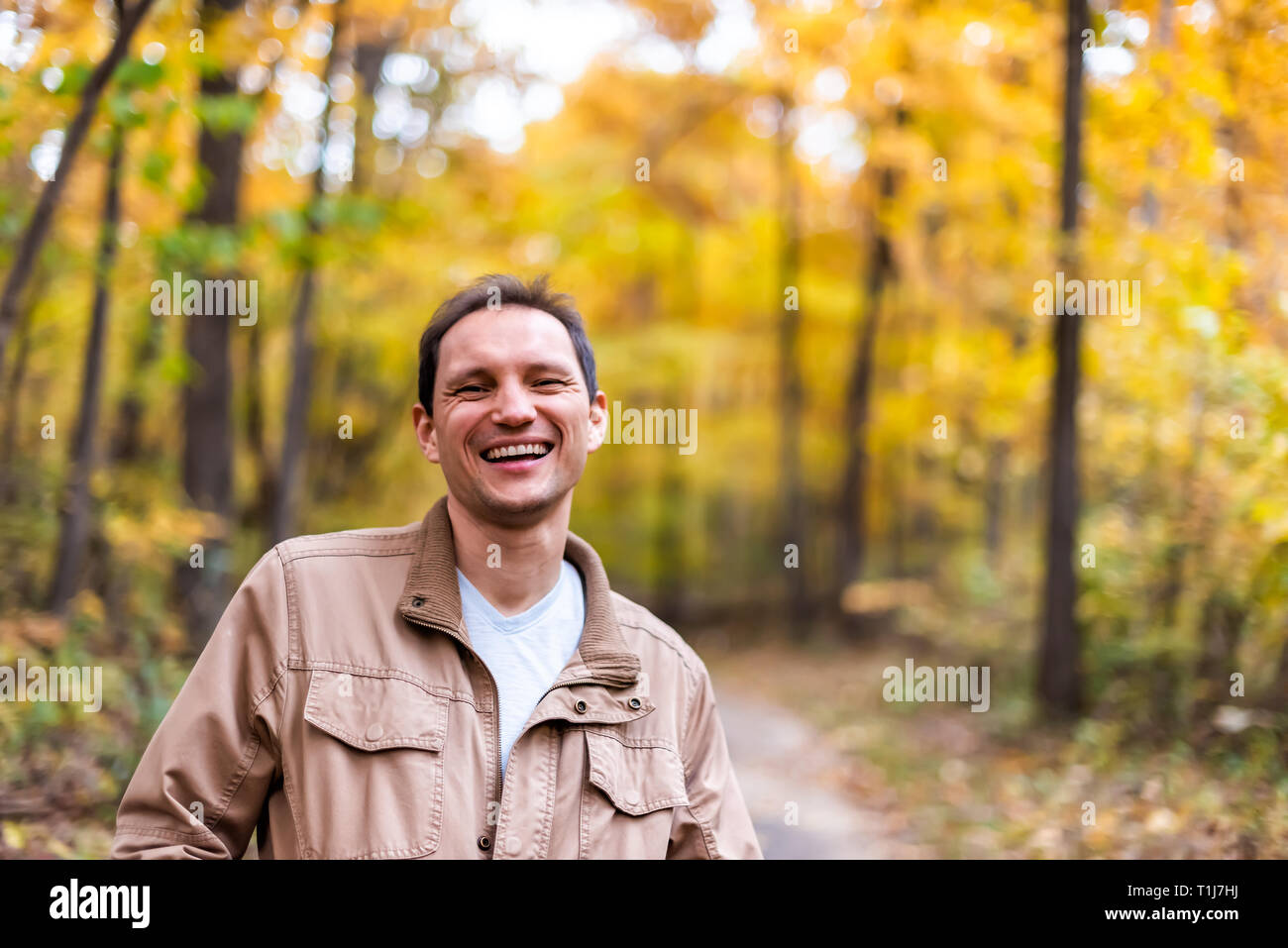 Virginia Arancio Giallo autunno sfondo di alberi in Fairfax County foglie colorate nel nord VA sul Sugarland eseguire Stream Valley Trail con uomo felice s Foto Stock