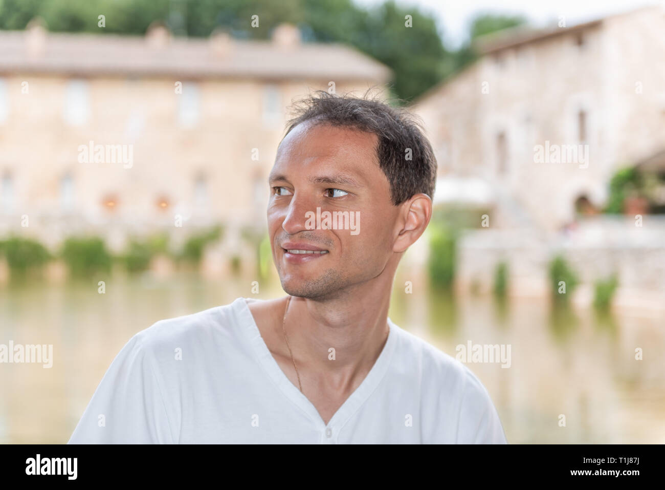 Bagno Vignoni, Italia città medievale di San Quirico d'Orcia nella Val d'Orcia Toscana con persone turista giovane uomo seduto con il fondo della piscina histor Foto Stock