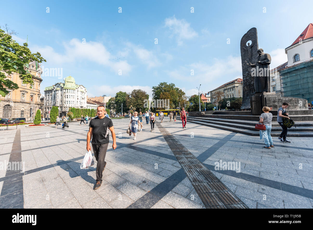 Lviv, Ucraina - 1 Agosto 2018: la gente a piedi la libertà o prospekt Svobody boulevard street con Tara Shevchenko statua monumento stele con rilievo Foto Stock