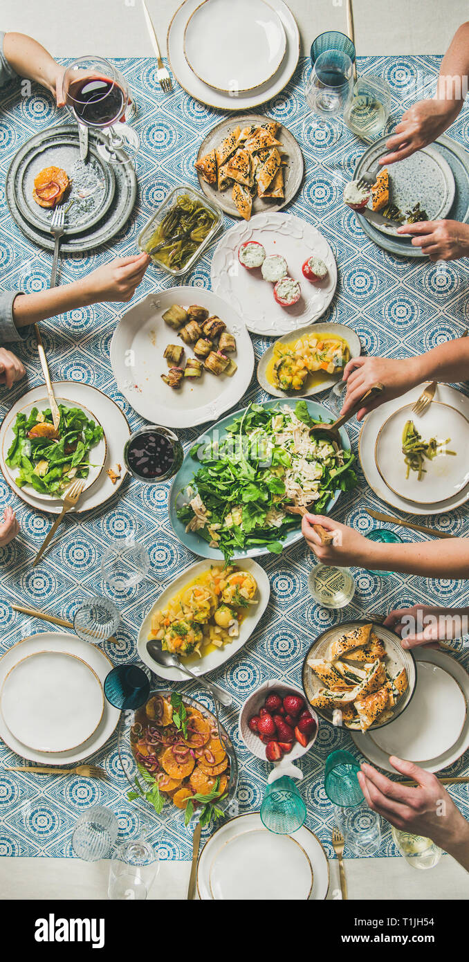 Lo stile mediterraneo cena e mani umane tenendo cibo e bevande Foto Stock