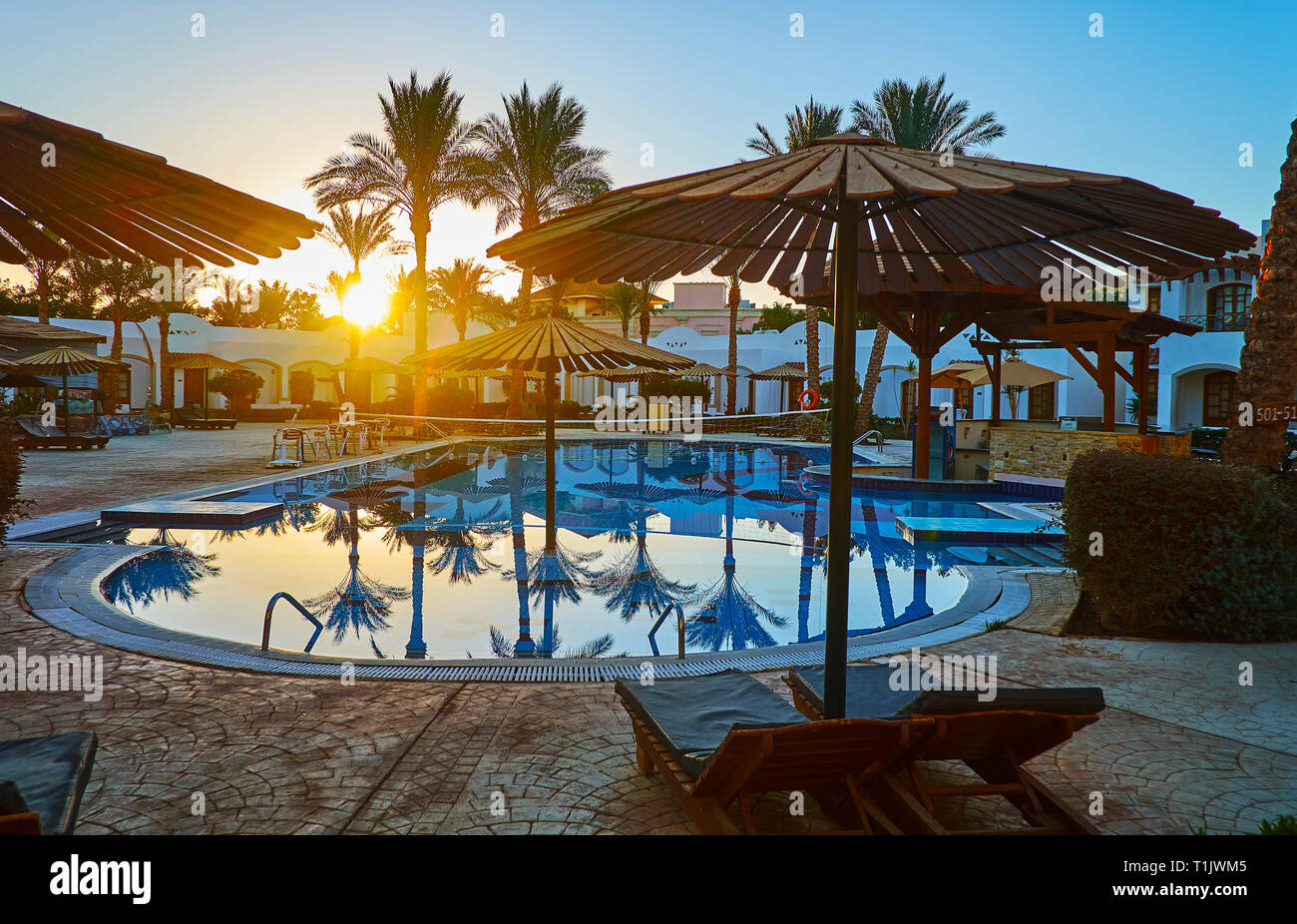 SHARM EL SHEIKH, Egitto - 12 dicembre 2017: Godetevi il sunrise, di relax presso la piscina con una vista sulle palme, ombrelloni e cottage intimi dell hotel, su De Foto Stock