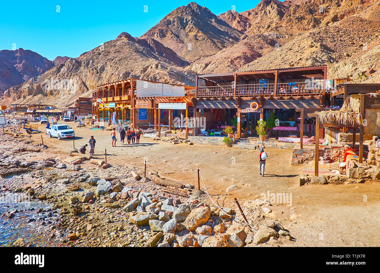 DAHAB, Egitto - 16 dicembre 2017: la linea di ristoranti di fronte di deserto di rocce sulla riva del Buco Blu snorkeling spot, popolare tra i turisti, Foto Stock