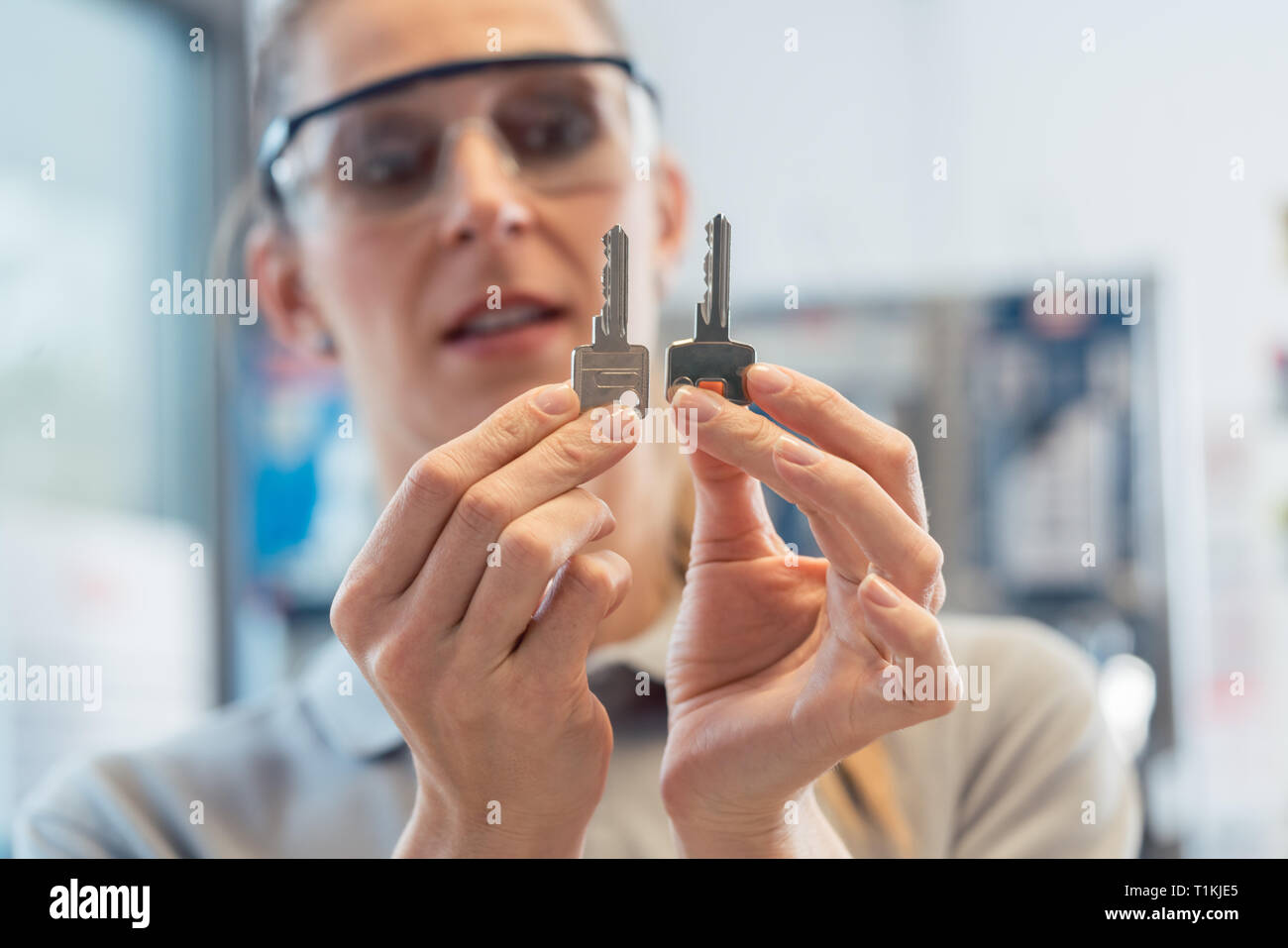 Donna con chiave taglierina shop guardando gli sbozzati Foto Stock