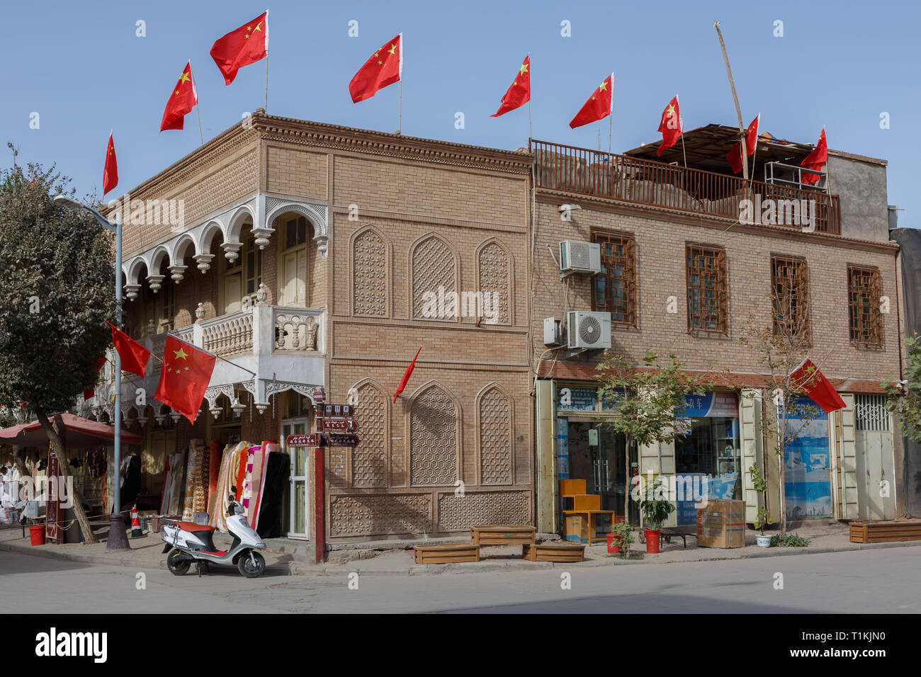 Casa di intersezione in Kashgar Old Town. Numerose bandiere cinesi sono sul tetto - non solo un segno di Anno Nuovo Cinese Foto Stock