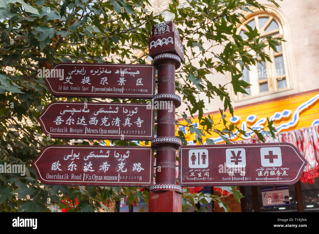 Multi-lingua segnaletica direzionale in Kashgar Old Town. Puntando verso punti panoramici (simili alla Moschea Id Kah) e altre utili destinazioni (come servizi igienici). Foto Stock