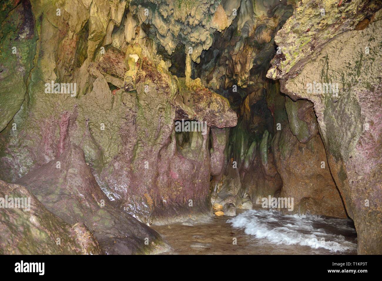 Lavaggio d'onda attraverso una piccola grotta di calcare a Cuevas del Mar (grotte marine) spiaggia, vicino a Llanes, Asturias, Spagna, Agosto. Foto Stock