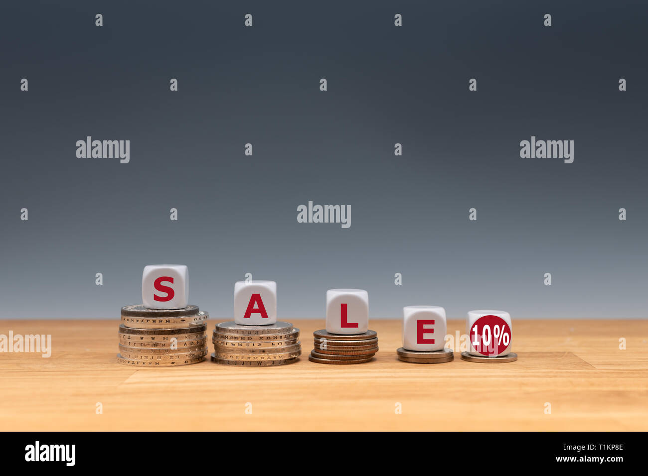 Simbolo per una vendita con un 10 % di sconto. Dadi posti sulle monete formano l'espressione 'sale 10%'. Foto Stock