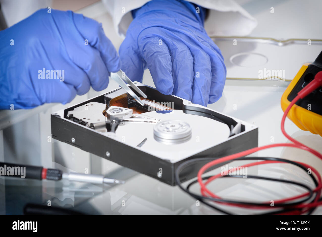 Uomo di servizio che fissa il guasto del disco e le mani protette da guanti. Foto Stock