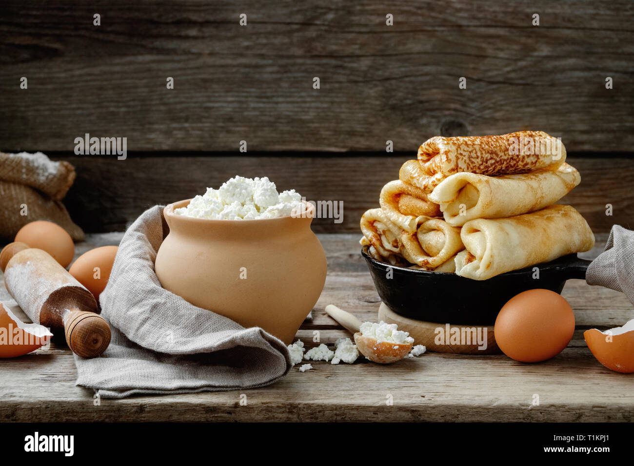 Padella di pancake cotti al forno, ingredienti e utensili da cucina per frittelle rendendo sulla cucina in legno tavolo. Foto Stock