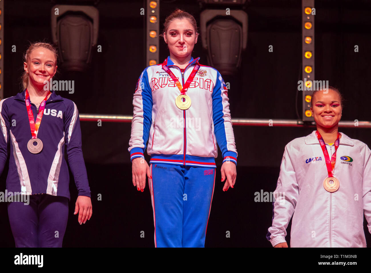 Birmingham, Inghilterra, Regno Unito. 23 marzo, 2019. Gli Stati Uniti' Riley McCusker (argento), la Russia Aliya Mustafina (oro) e Brasile Thais Fidélis (bron Foto Stock