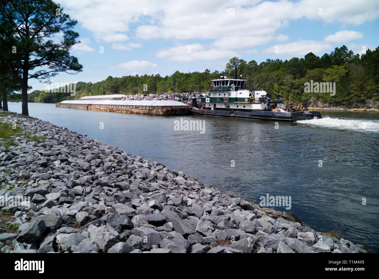 Rimorchiatore spinge una chiatta verso ovest sulla Intracoastal Waterway attraverso Orange Beach, Alabama. Foto Stock