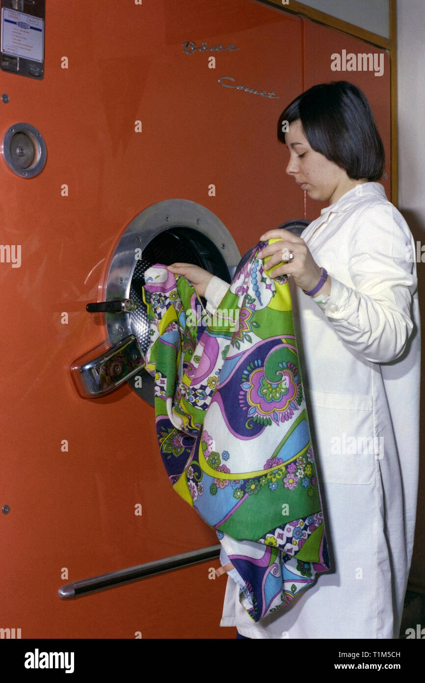 Rimozione donna biancheria da una grande cometa industriale macchina di lavaggio degli anni settanta Ungheria Foto Stock