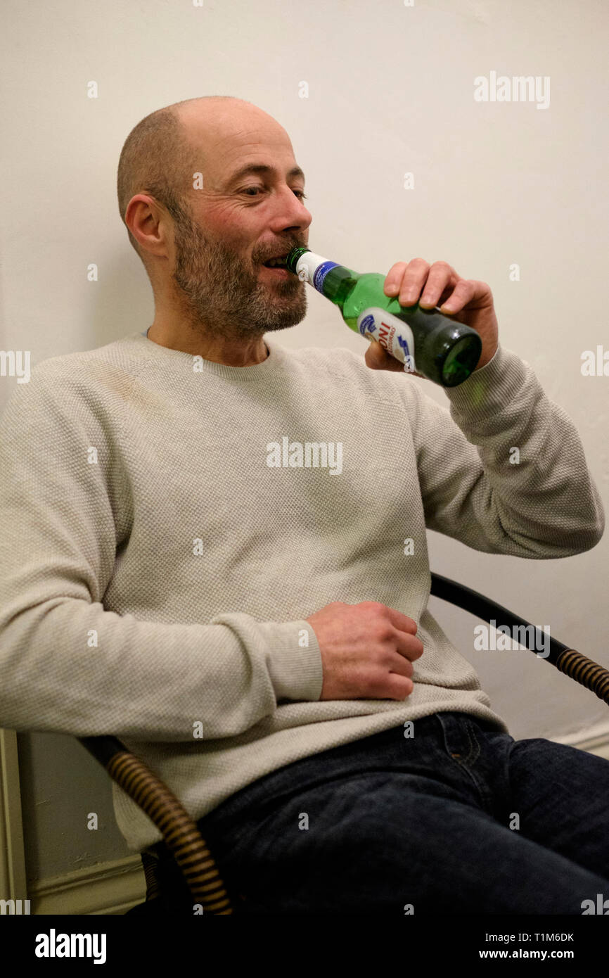 Uomo con una bottiglia di birra ad un house party southsea England Regno Unito Foto Stock