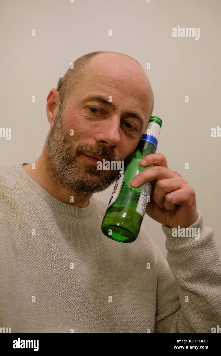 Uomo con una bottiglia di birra ad un house party southsea England Regno Unito Foto Stock