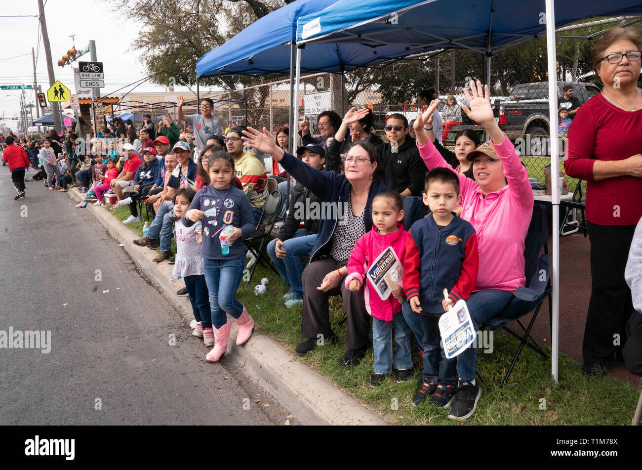 Multi-generazionale folla orologi da marciapiede come l'annuale a Washington la celebrazione di compleanno parade passa nella città di Laredo in Texas. Foto Stock