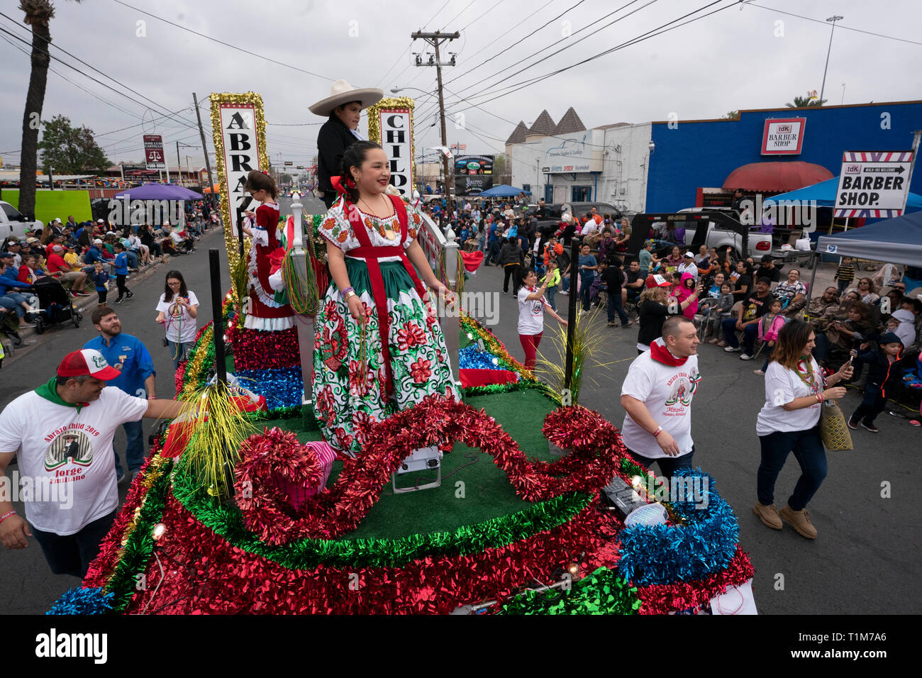 Ragazza in costume sul galleggiante getta perle in folla nel corso annuale di Washington la celebrazione di compleanno parade di Laredo, TX Foto Stock