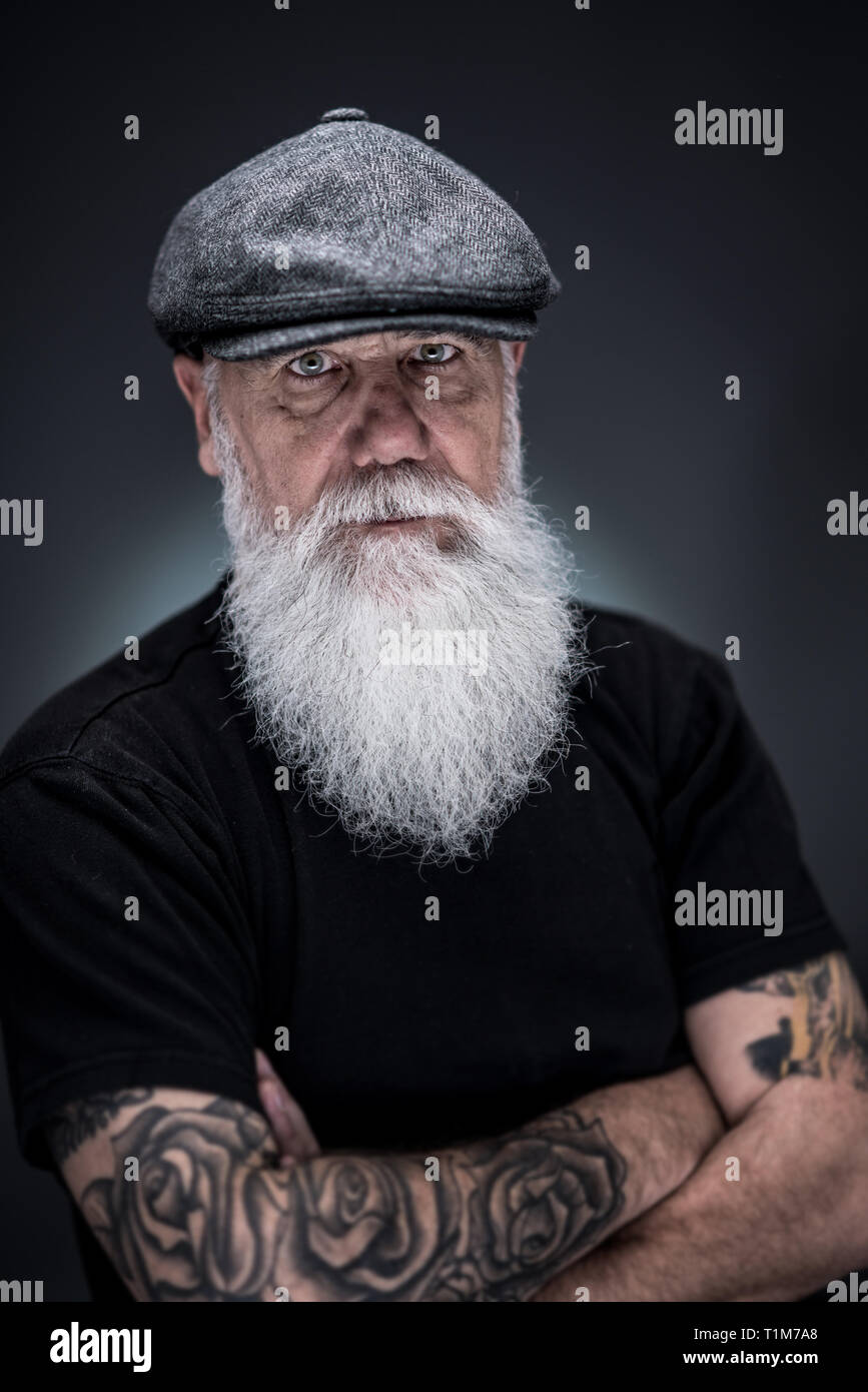 Ritratto in studio di un senior hipster con una lunga barba bianca Foto Stock