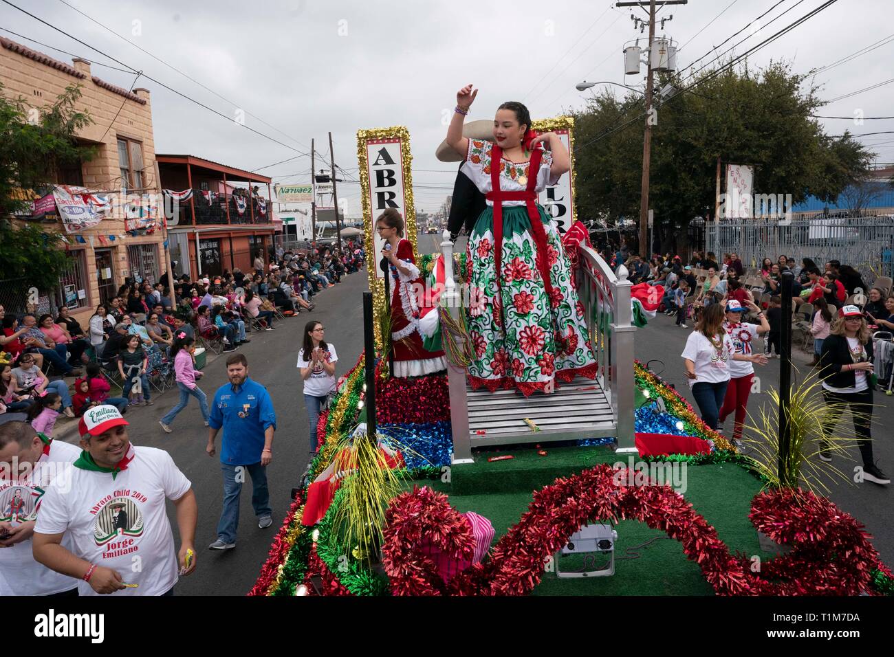 Ragazza in costume sul galleggiante getta perle in folla nel corso annuale di Washington la celebrazione di compleanno parade di Laredo, TX Foto Stock