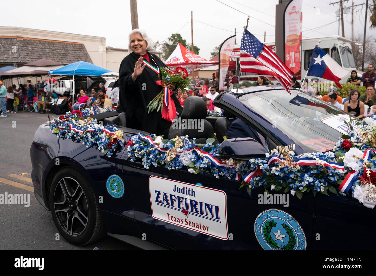 Texas State Sen. Judith Zaffrini onde dal retro di una decappottabile durante l annuale a Washington la celebrazione di compleanno parade di Laredo, Texas. Foto Stock