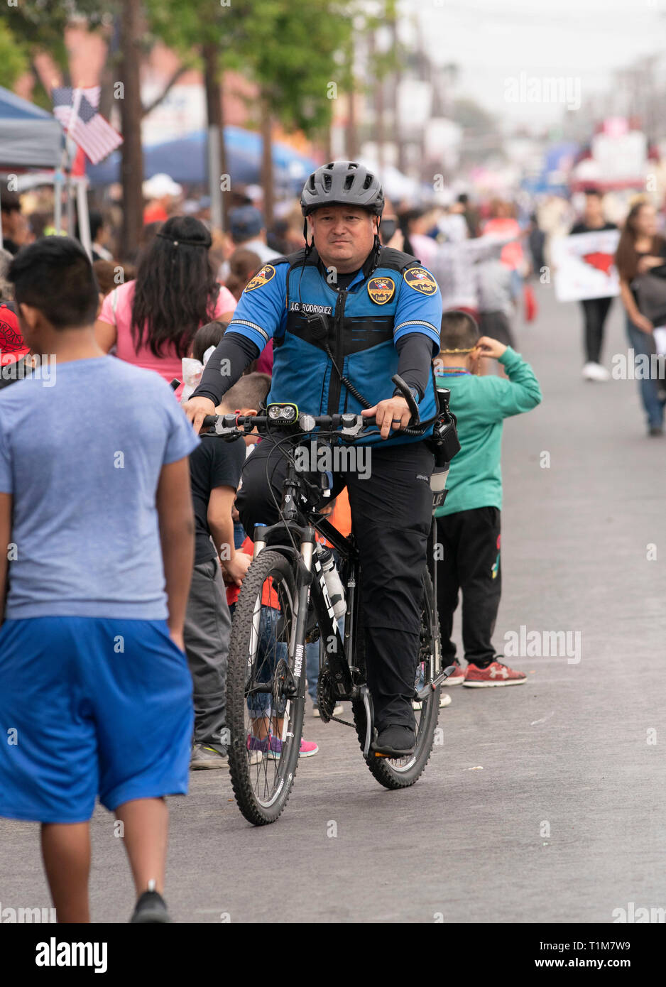 Funzionario di polizia su una bicicletta di pattuglie street durante l annuale a Washington la celebrazione di compleanno sfilata nel centro cittadino di Laredo, Texas, Stati Uniti d'America. Foto Stock