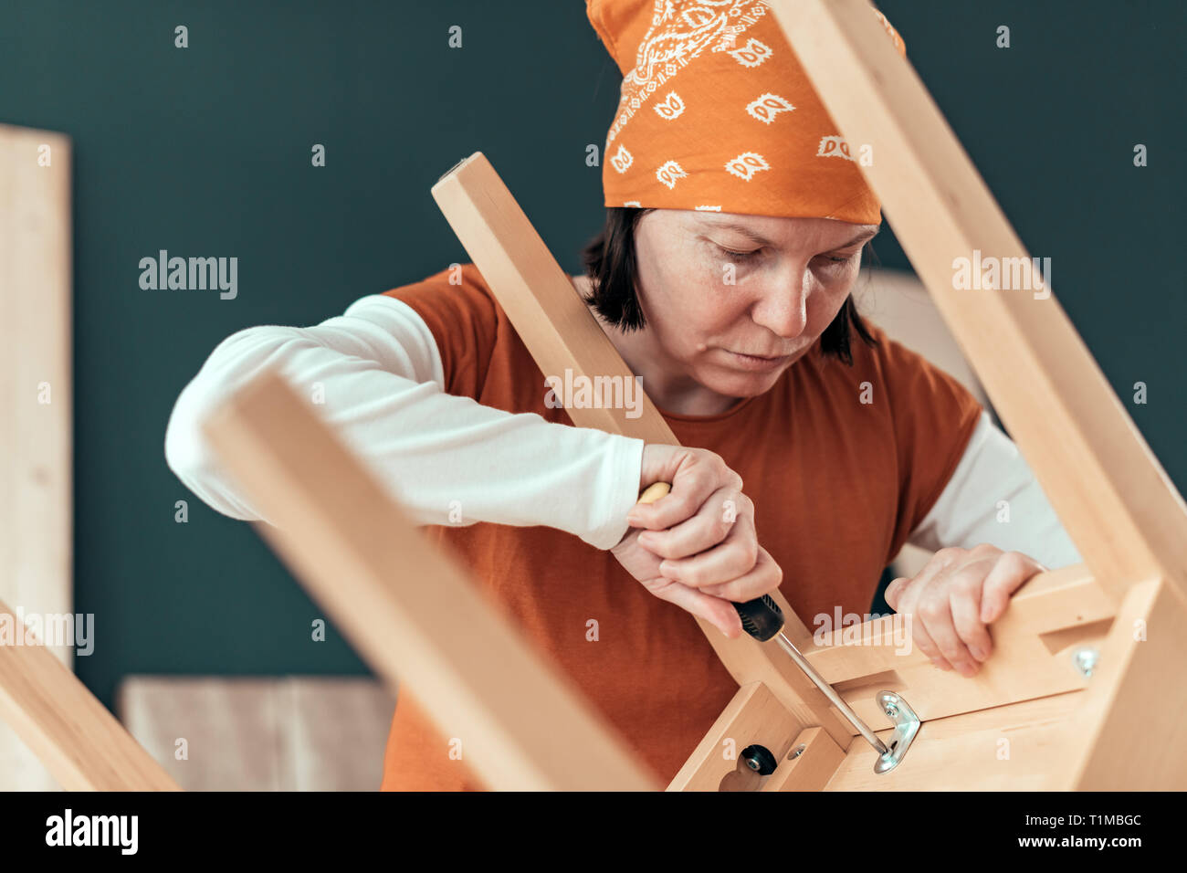 Falegname femmina la riparazione di sedia in legno sedile in small business workshop di falegnameria Foto Stock