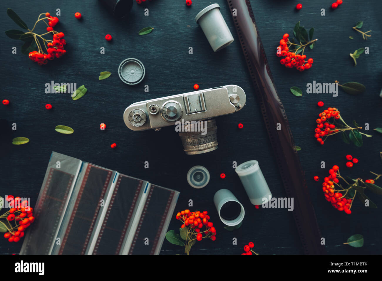 Piatto tanga laici vecchio stile vintage fotografia fotocamera sul legno scuro dello sfondo con composizioni floreali Foto Stock