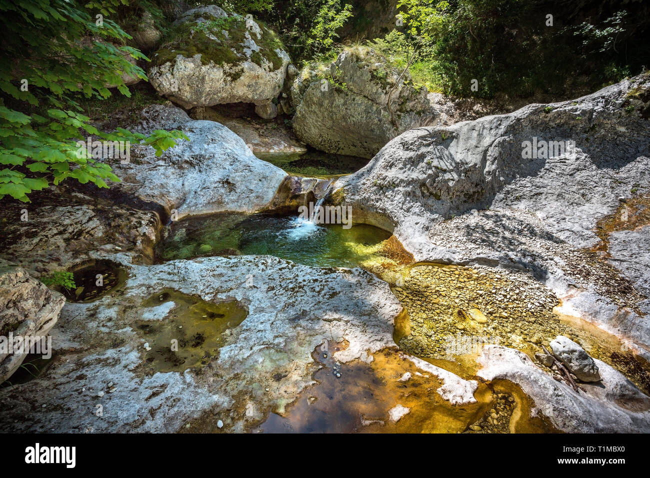 Piccolo ruscello che scorre morbido su rocce colorate Foto Stock