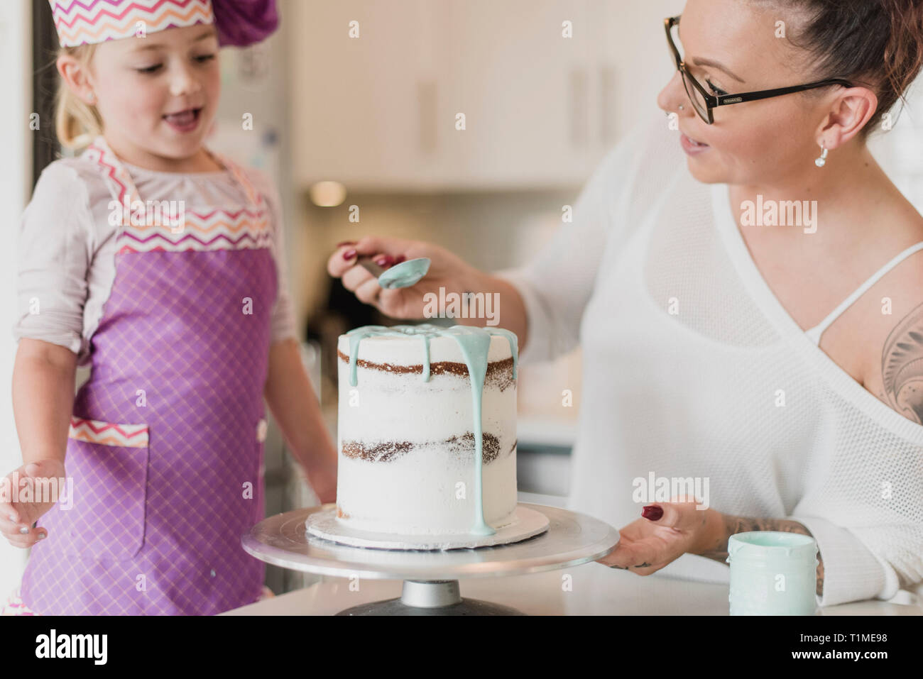 Madre e figlia decorare la torta Foto Stock