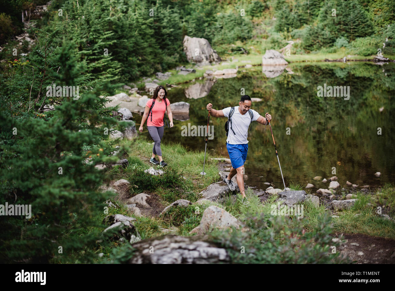 Escursionismo coppia lungo il lago nei boschi Foto Stock