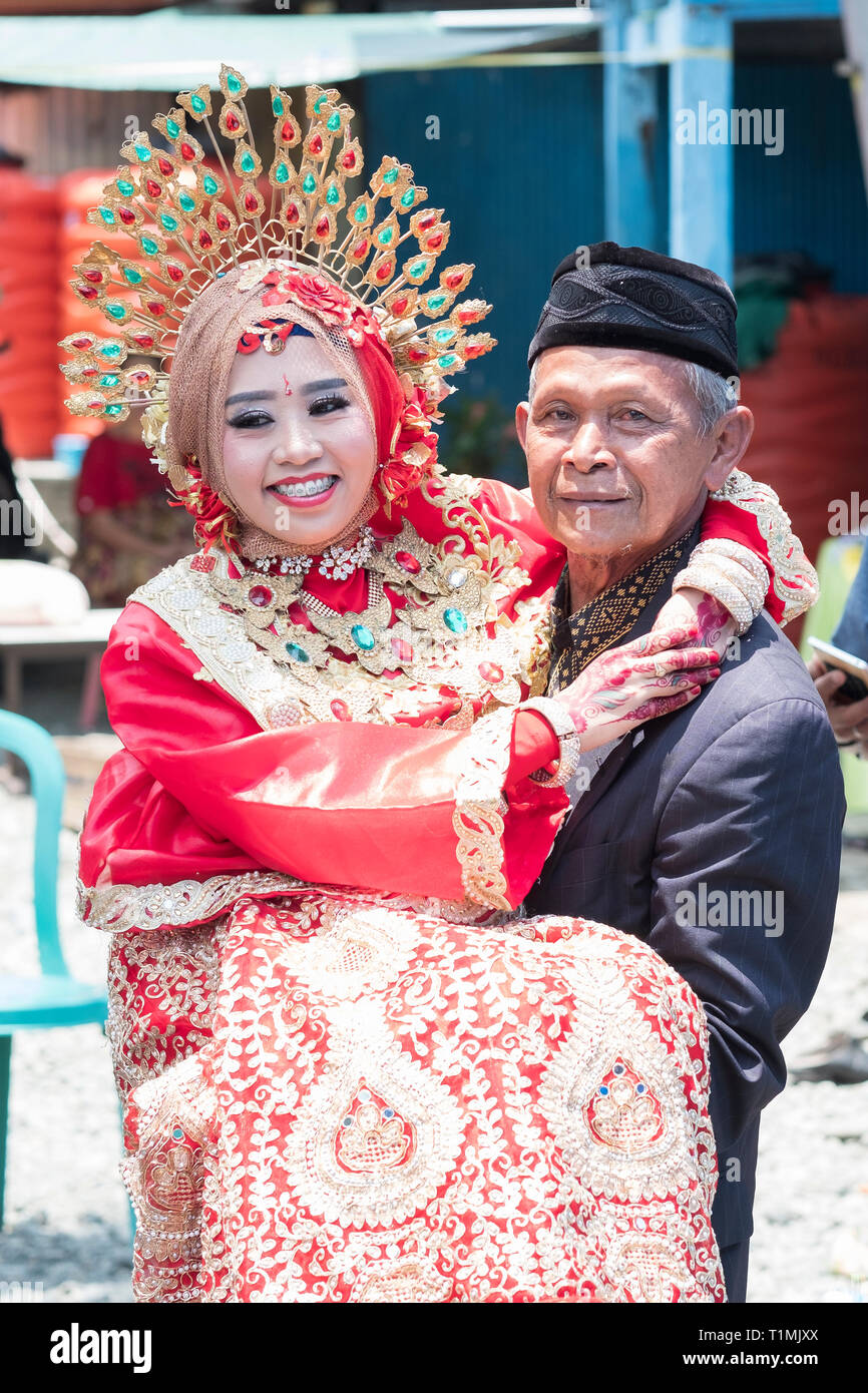 Un padre e la sua nuova figlia sposata indossando un tradizionale Sulawesi abito da sposa, Sulawesi, Indonesia Foto Stock