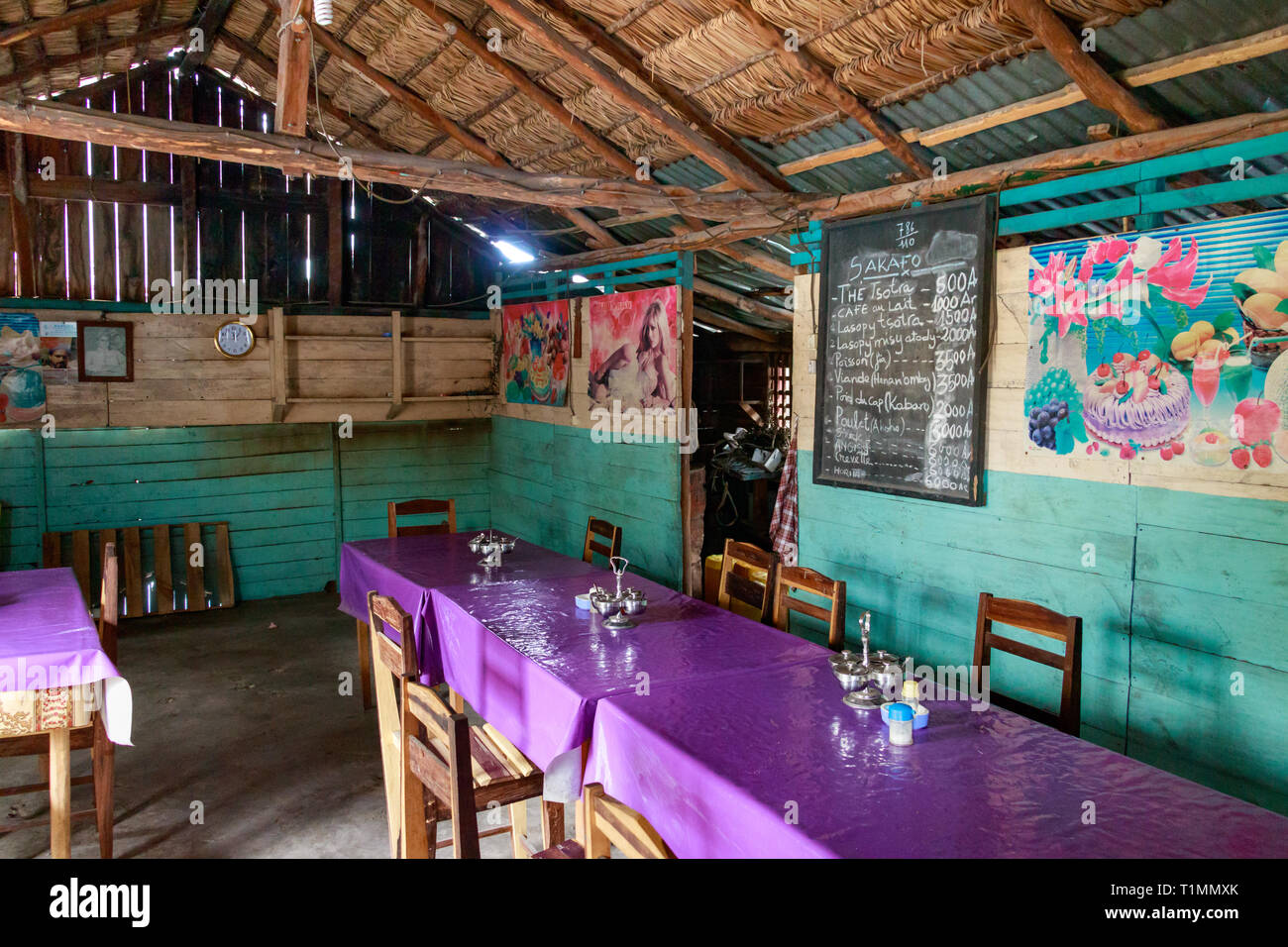 Andavadoaka, Madagascar - Gennaio 13th, 2019: un menu scritto su una lavagna a fogli mobili su una parete in legno, sedie e tavoli in un ristorante rustico nel centro di mar Foto Stock