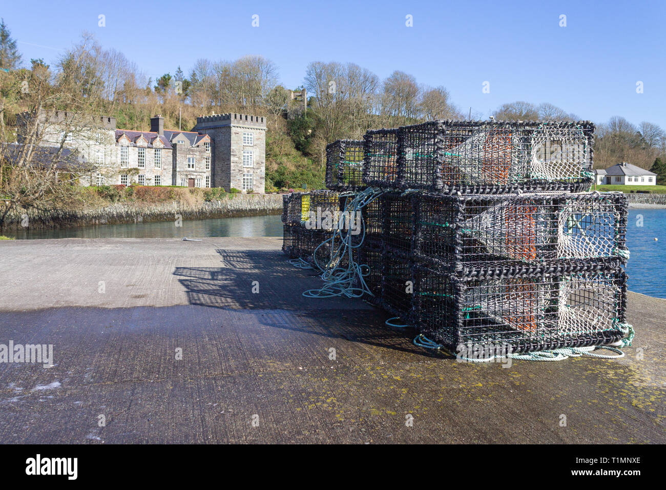 Lobster Pot su una banchina con un castello in background, castletownshend, West Cork, Irlanda Foto Stock