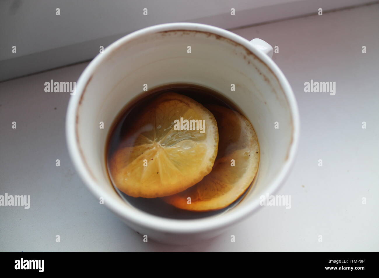 Porcellana Bianca cup con nero a caldo il caffè al mattino con la fetta di limone in Foto Stock