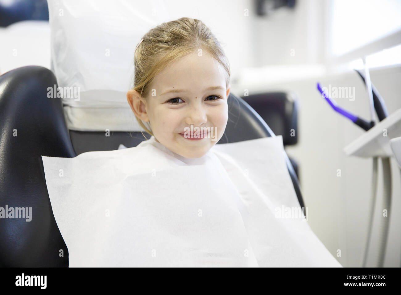 Sorridente bambina nello studio dentistico. Prevenzione, pediatrici per la cura dentale concetto. Foto Stock