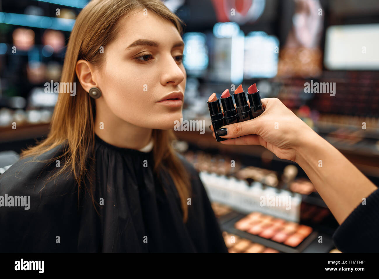 Visagiste e il cliente sceglie un rossetto, trucco shop Foto Stock