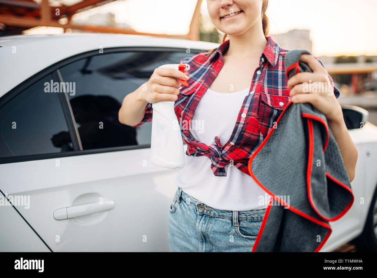 Donna lucidi auto dopo il lavaggio a macchina di lavaggio Foto Stock