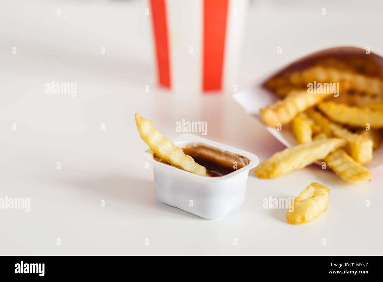 Patatine fritte e cola su uno sfondo bianco, il fuoco selettivo, copia dello spazio. Foto Stock