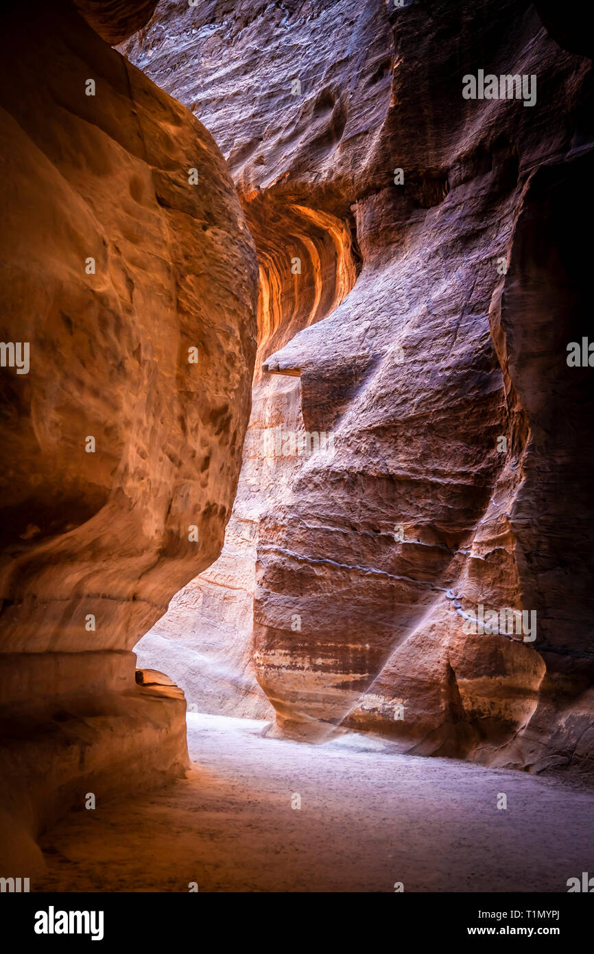 Percorso suggestivo all'interno del canyon di arenaria che conduce al tesoro di Petra, Giordania. Foto Stock