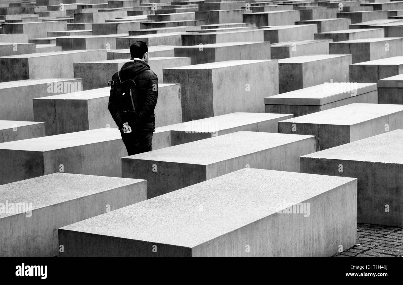 Uomo che cammina attraverso il memoriale per gli ebrei assassinati a Berlino Germania Foto Stock