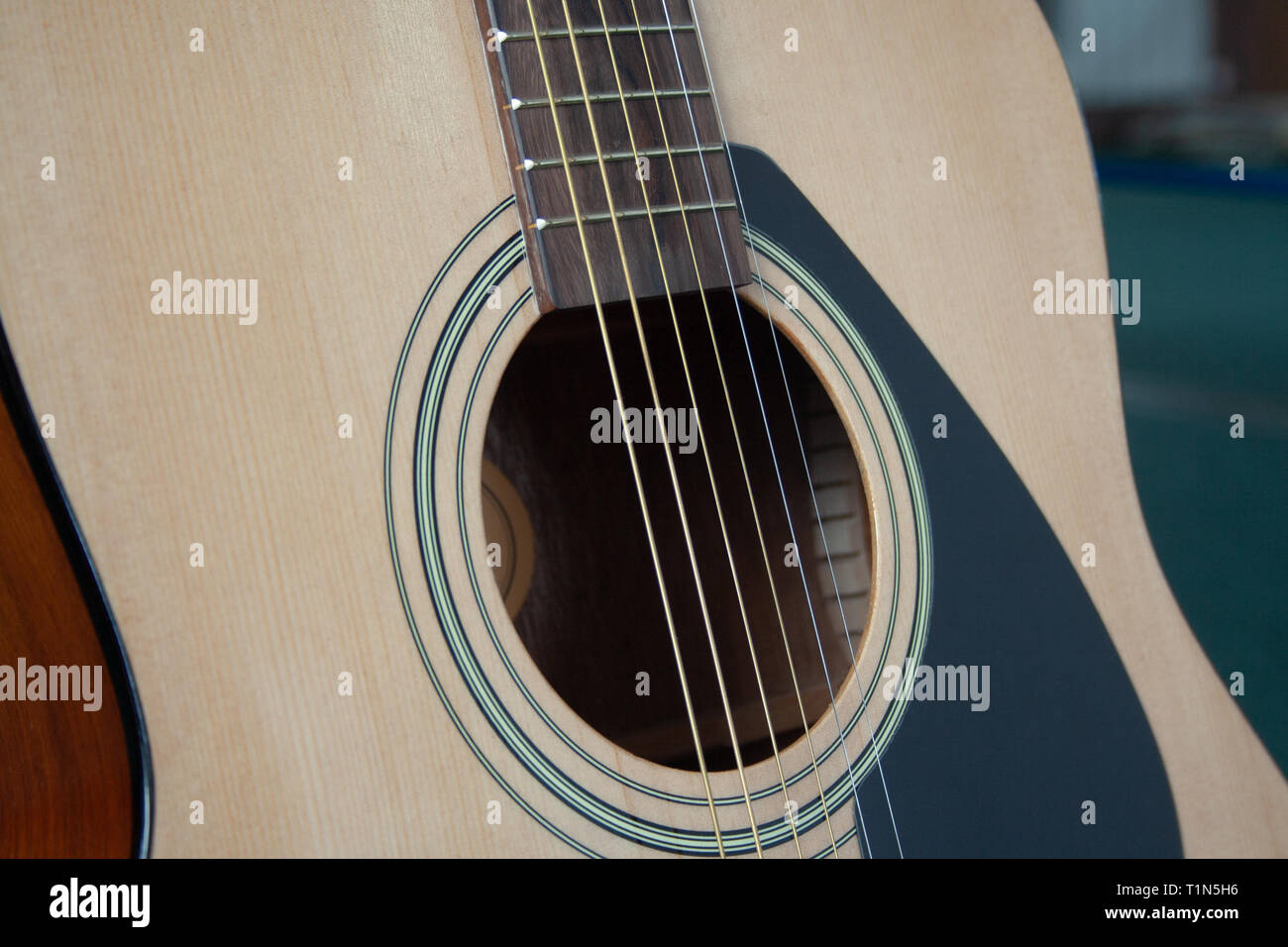 Close up di chitarra acustica con le corde di metallo. Il concetto di musica. Hobby, tempo libero concetto. Imparare a suonare la chitarra. Foto Stock